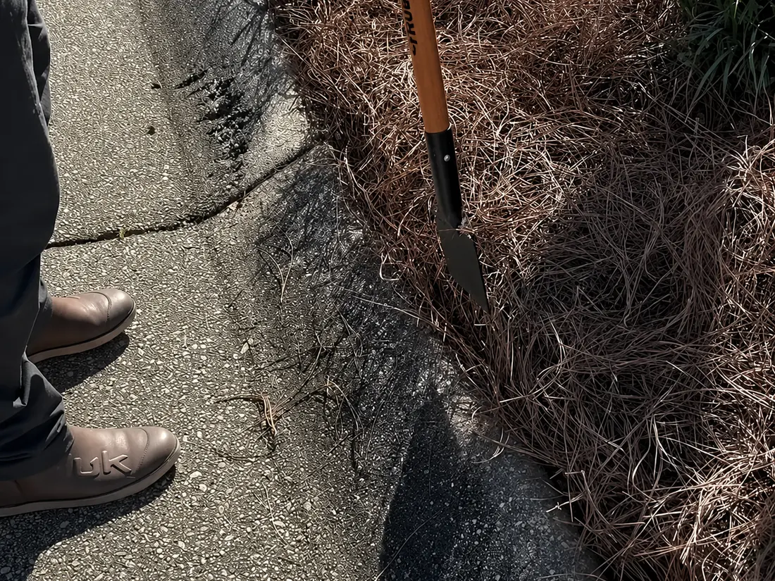 Spade work along the drive Trench and Tuck edging in progress, spade cutting a clean line at the pavement